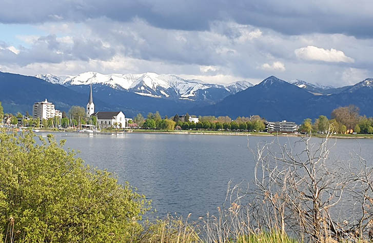 Ein See inb Hard, mit schneebedeckten Bergen im Hintergrund.